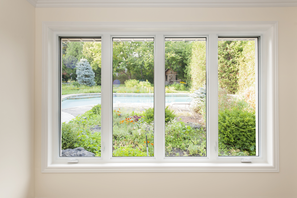 Large,four,pane,window,looking,on,summer,backyard,with,pool