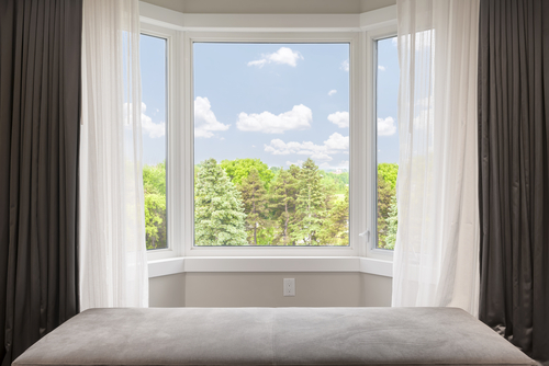 Bay,window,with,drapes,,curtains,and,view,of,trees,under